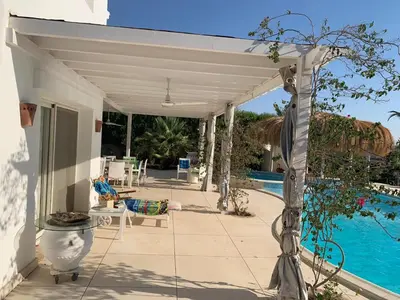 a white pergola over a patio with a pool at Snow White Villa in Hurghada