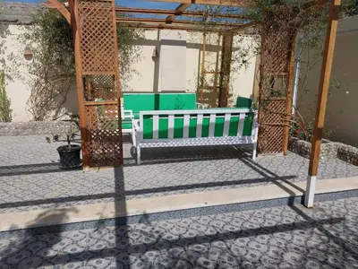 a green bench sitting under a gazebo at Jasmine villa in Hurghada