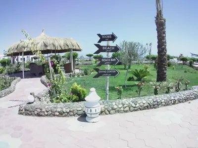 a sign with arrows pointing in different directions in a park at Dolphin Continental Hotel in Quseir