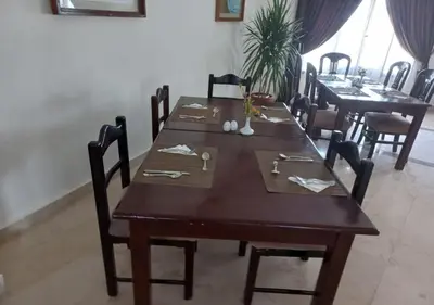 a dining room with a wooden table and chairs at Dolphin Continental Hotel in Quseir