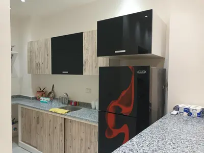 a kitchen with a black refrigerator with flames painted on it at Cleopatra Resort F16 in Hurghada