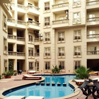 a large building with a swimming pool in front of it at Cleopatra Resort F16 in Hurghada