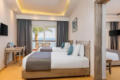 a bedroom with two beds and a view of the ocean at Sunrise Alma Bay Resort in Hurghada