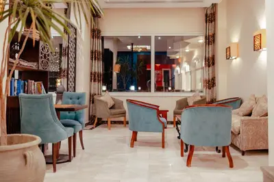 a living room with blue chairs and a table at Royal Star Beach Resort in Hurghada