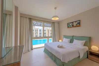 a bedroom with a bed and a large window at Mangroovy 2 Bedroom Sea View Apartment, Pool & Beach in Hurghada