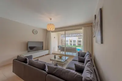 a living room with a couch and a tv at Mangroovy 2 Bedroom Sea View Apartment, Pool & Beach in Hurghada