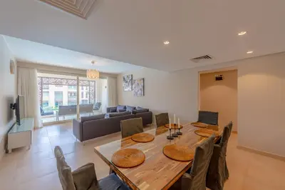 a living room with a wooden table and a couch at Mangroovy 2 Bedroom Sea View Apartment, Pool & Beach in Hurghada