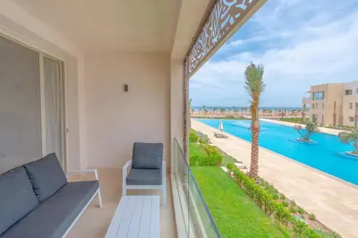 a balcony with a view of a swimming pool at Mangroovy 2 Bedroom Sea View Apartment, Pool & Beach in Hurghada