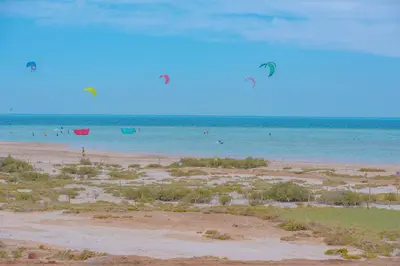 a beach with people flying kites in the water at Mangroovy 2 Bedroom Sea View Apartment, Pool & Beach in Hurghada
