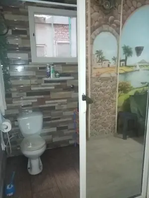 a bathroom with a toilet and a stone wall at Apartment near the sea in Hurghada