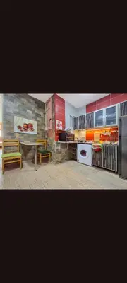 a kitchen with red cabinets and a table and a refrigerator at Apartment near the sea in Hurghada