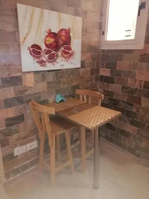 a table and chairs with a picture of pomegranates on the wall at Apartment near the sea in Hurghada