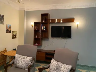 a living room with two chairs and a flat screen tv at PORTO HILL in Hurghada