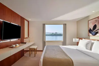 a hotel room with a large bed and a television at Mövenpick Royal Lotus Nile Cruise, Every Monday Four Nights From Luxor, Every Friday Three Nights From Aswan - Including Excursions & Sightseeing in Luxor