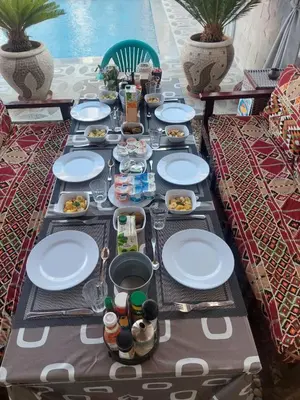 a long table with plates of food on it at CASA LOKO Guest House in Luxor