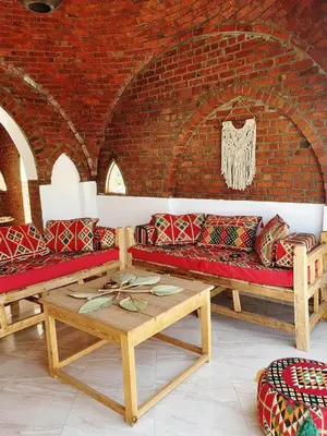 a living room with couches and a brick wall at CASA LOKO Guest House in Luxor