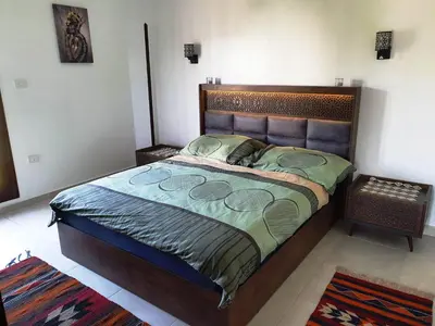 a bedroom with a large bed with a wooden headboard at CASA LOKO Guest House in Luxor
