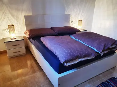 a bedroom with a large bed with two night stands at CASA LOKO Guest House in Luxor