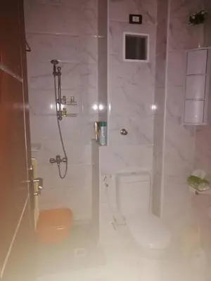 a white bathroom with a toilet and a shower at Studio in compaund in Hurghada