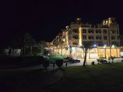 a large building at night with palm trees and buildings at Sahl Hasheesh, El Andalous by All View apartements in Hurghada