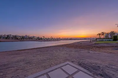 a view of the beach at sunset at Joubal Lagoon II 4-Bedroom Villa with Private Pool & Lagoon Views in Hurghada