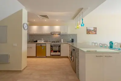 a kitchen with white cabinets and yellow appliances at Joubal Lagoon II 4-Bedroom Villa with Private Pool & Lagoon Views in Hurghada