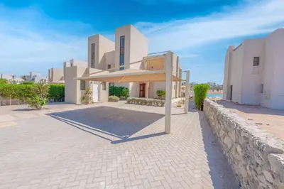 a large white house with a stone wall at Joubal Lagoon II 4-Bedroom Villa with Private Pool & Lagoon Views in Hurghada