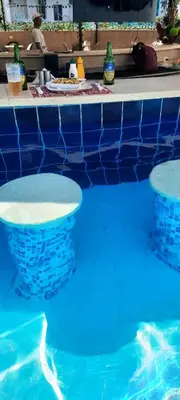 a swimming pool with two chairs in the water at Aqua Palms resort -Lovely studio in Hurghada