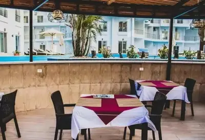 a restaurant with tables and chairs and a pool at Aqua Palms resort -Lovely studio in Hurghada