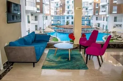 a living room with a couch and chairs and a pool at Aqua Palms resort -Lovely studio in Hurghada