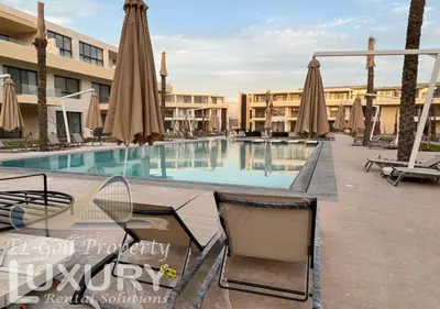 a swimming pool in a resort with umbrellas and chairs at G-Cribs 2 Bed Rooms in Hurghada