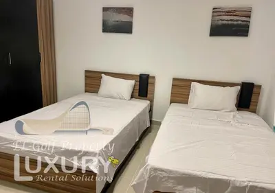 a bedroom with two beds with a hat on them at G-Cribs 2 Bed Rooms in Hurghada