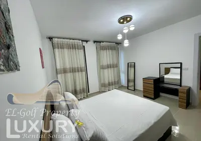 a bedroom with a bed and a dresser and a mirror at G-Cribs 2 Bed Rooms in Hurghada