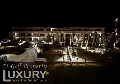 a building at night with a pool in front of it at G-Cribs 2 Bed Rooms in Hurghada