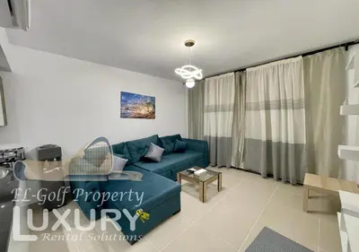 a living room with a blue couch and a table at G-Cribs 2 Bed Rooms in Hurghada