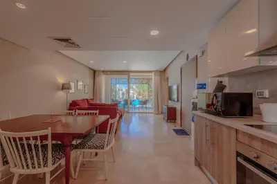 a kitchen and living room with a table and chairs at Elegant 2-Bedroom Apartment in Mangroovy, Pool & Beach in Hurghada