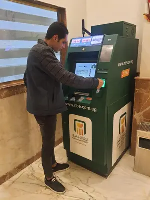 a man putting money into a atm machine at Tiba Rose hurghada in Hurghada