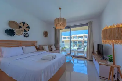a bedroom with a bed and a living room at Boho-Chic Studio Apartment in G-Cribs, Pool View in Hurghada