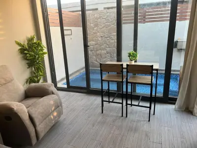 a living room with a couch and a table and chairs at Lovely 1BR with Private Heated pool at El-Gouna in Hurghada