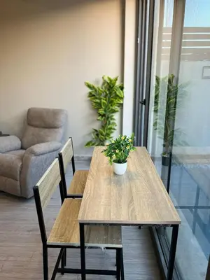 a wooden table and chairs with a potted plant on it at Lovely 1BR with Private Heated pool at El-Gouna in Hurghada