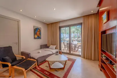a living room with a couch and a tv at Classy 1-Bedroom Apartment in Ancient Sands with Pool View in Hurghada