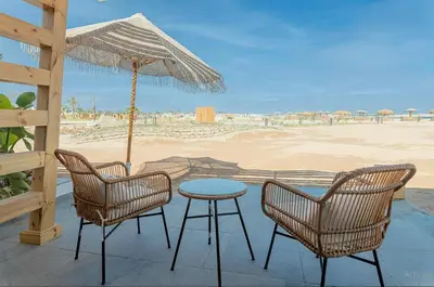 a patio with a table and chairs and a beach at Stayr Somabay - Bay Life Home Rentals in Hurghada