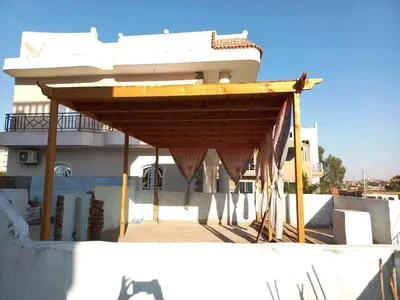 a building with a wooden canopy in front of a building at Villa Victoria Old Nile View in Luxor
