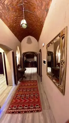 a hallway with a rug on the floor and a mirror at Villa Nur in Luxor
