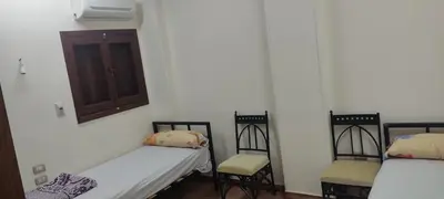 a room with two beds and two chairs at Luxor in Luxor