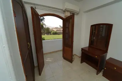 a hallway with a door and a dresser and a window at Flower of Desert in Luxor