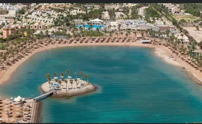 an aerial view of a beach with chairs and umbrellas at Le Mirage bay resort and aqua park one bedroom private studio inside view aqua building in Hurghada