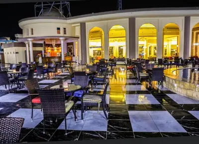 a restaurant with tables and chairs at night at Le Mirage bay resort and aqua park one bedroom private studio inside view aqua building in Hurghada