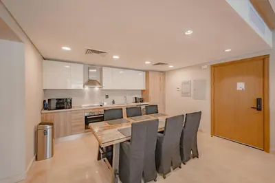 a kitchen with a dining room table and chairs at High Standard 2-Bedroom in Mangroovy Residence, Pool View & Beach in Hurghada