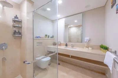 a bathroom with a shower and a toilet and a sink at High Standard 2-Bedroom in Mangroovy Residence, Pool View & Beach in Hurghada